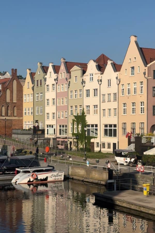 Colourful tenement houses along Motlawa River, Gdansk with relections on the river surface.