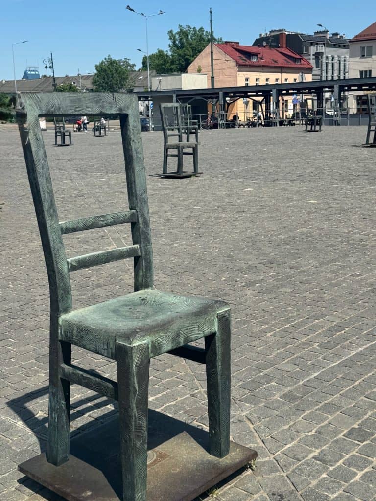 Metal chair sculptures in Ghetto Heroes Square, Krakow, symbolizing the absence and memory of Jewish residents during WWII.